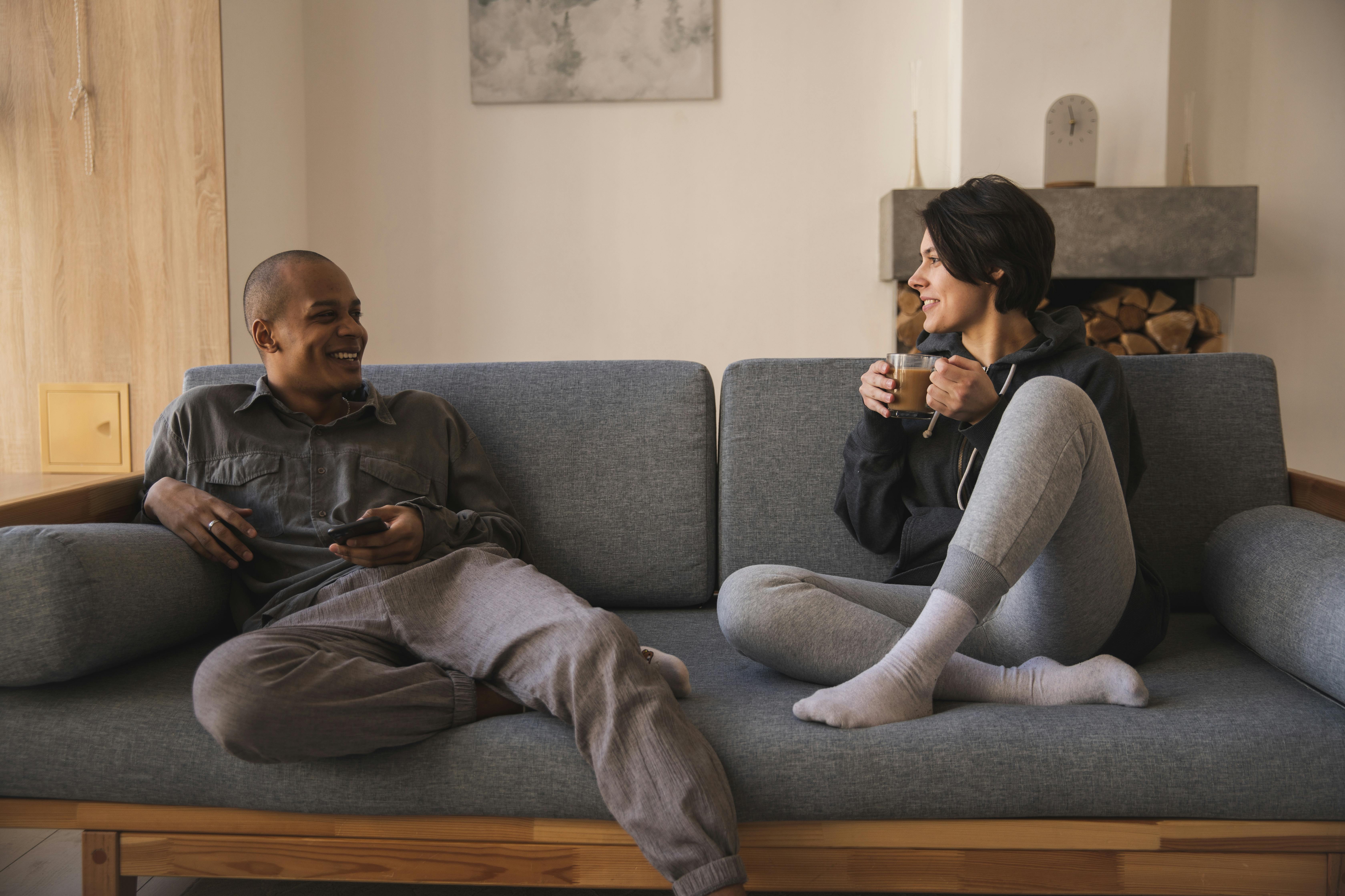 happy-young-multiracial-couple-taking-on-sofa-at-home