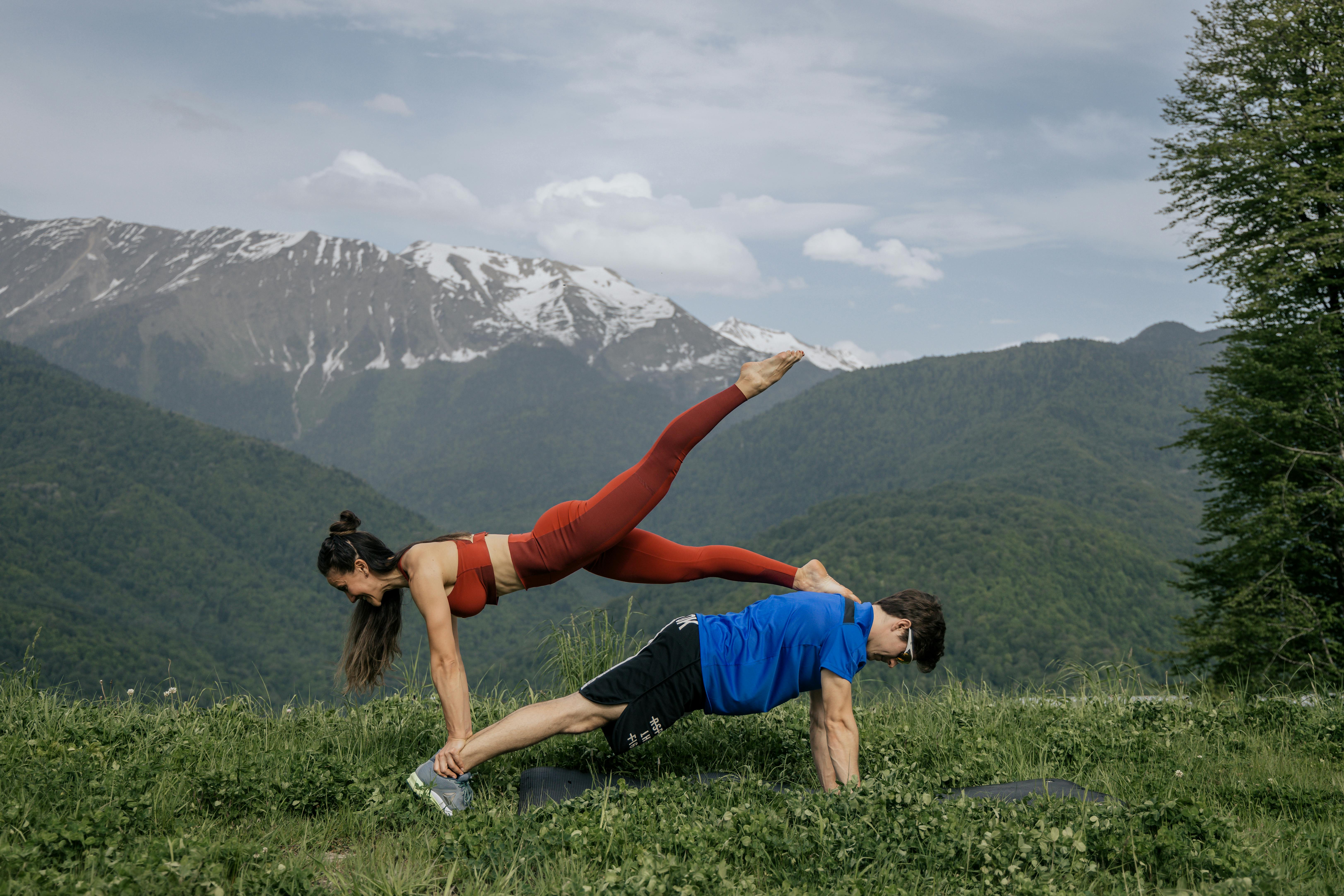 couple doing yoga on a mountain