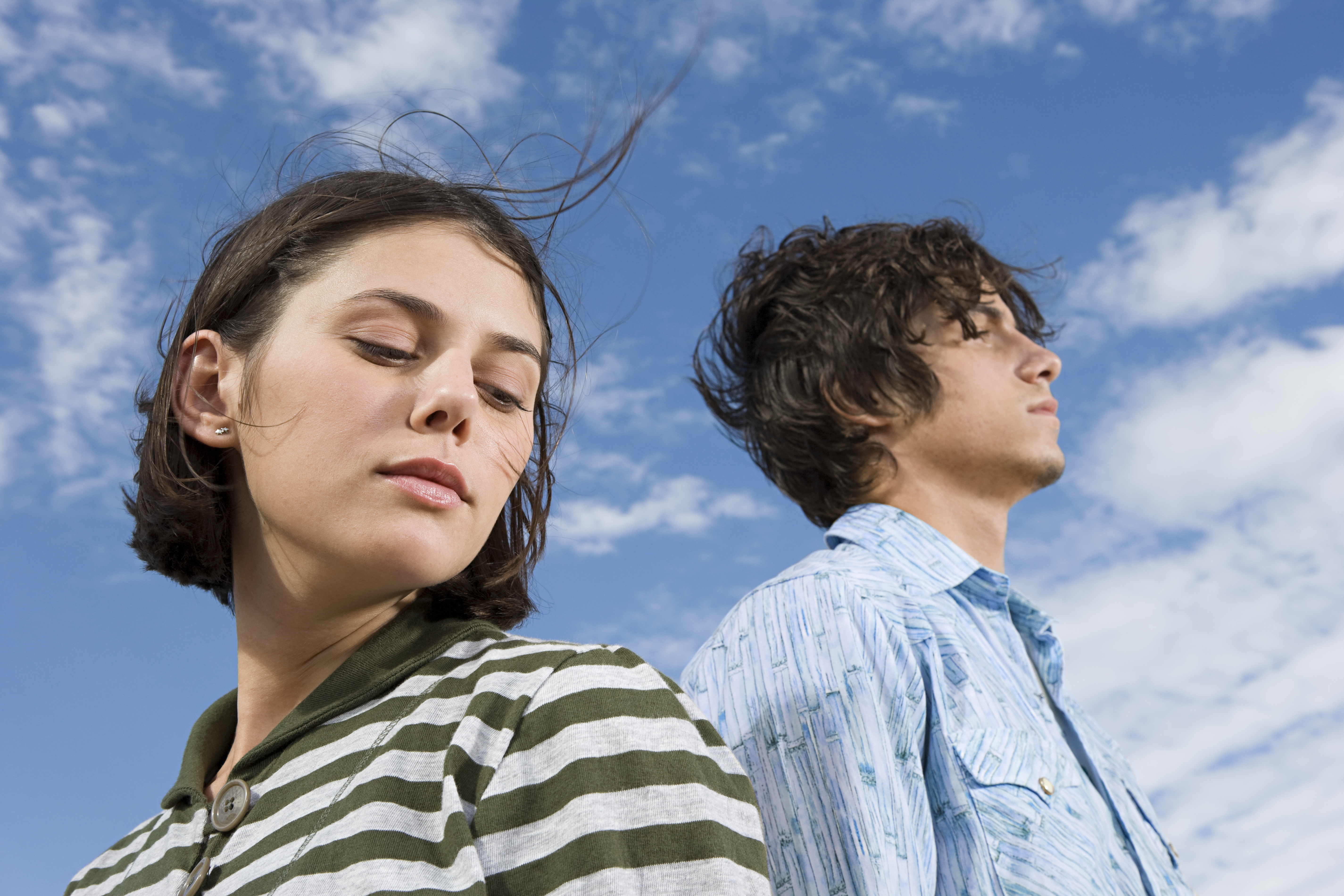 A young couple stands confidently beneath a vast, open sky, embodying a free-spirited and serene "sky personality."