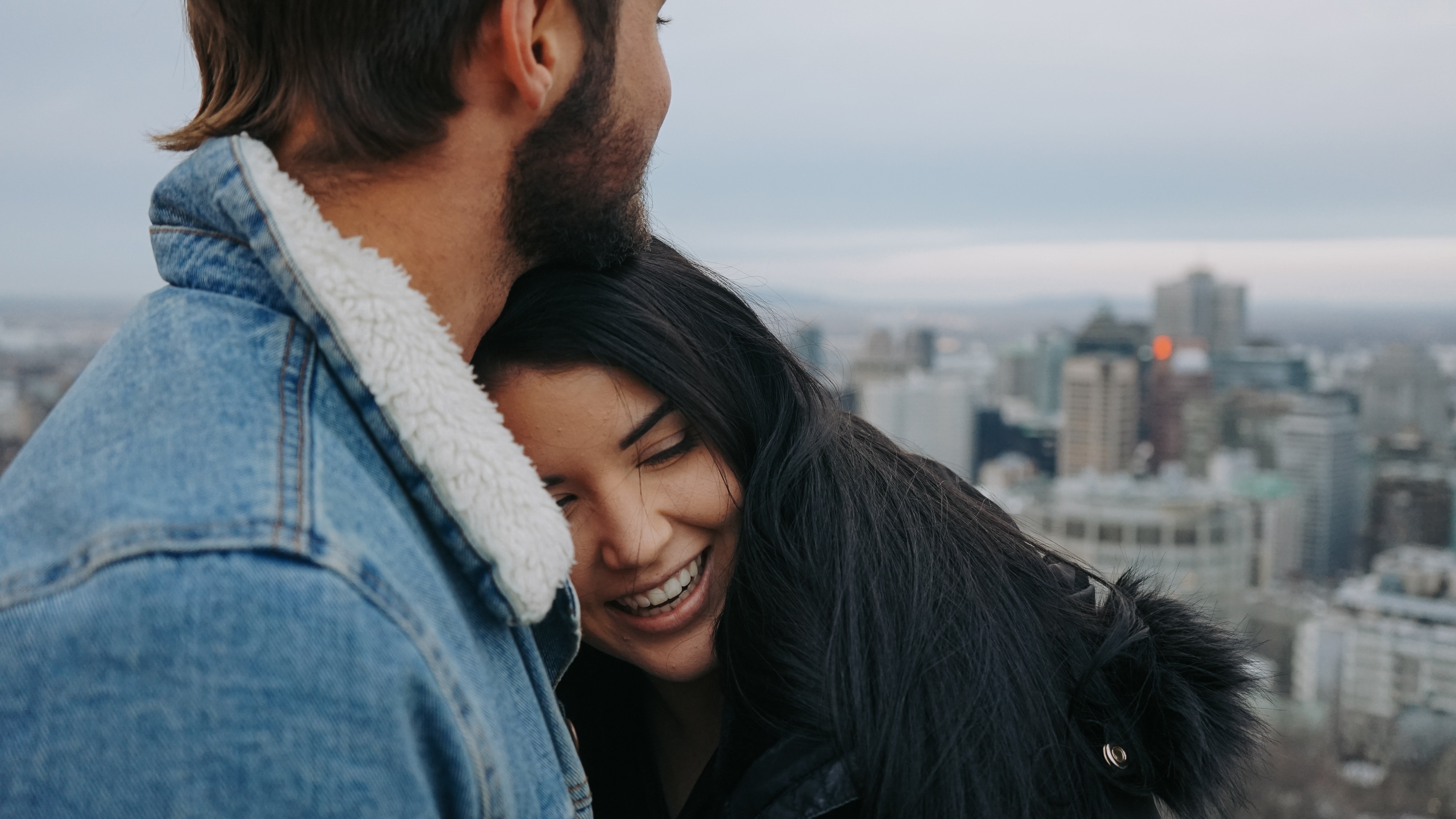 girl laying head on boyfriend as they look at city skyline