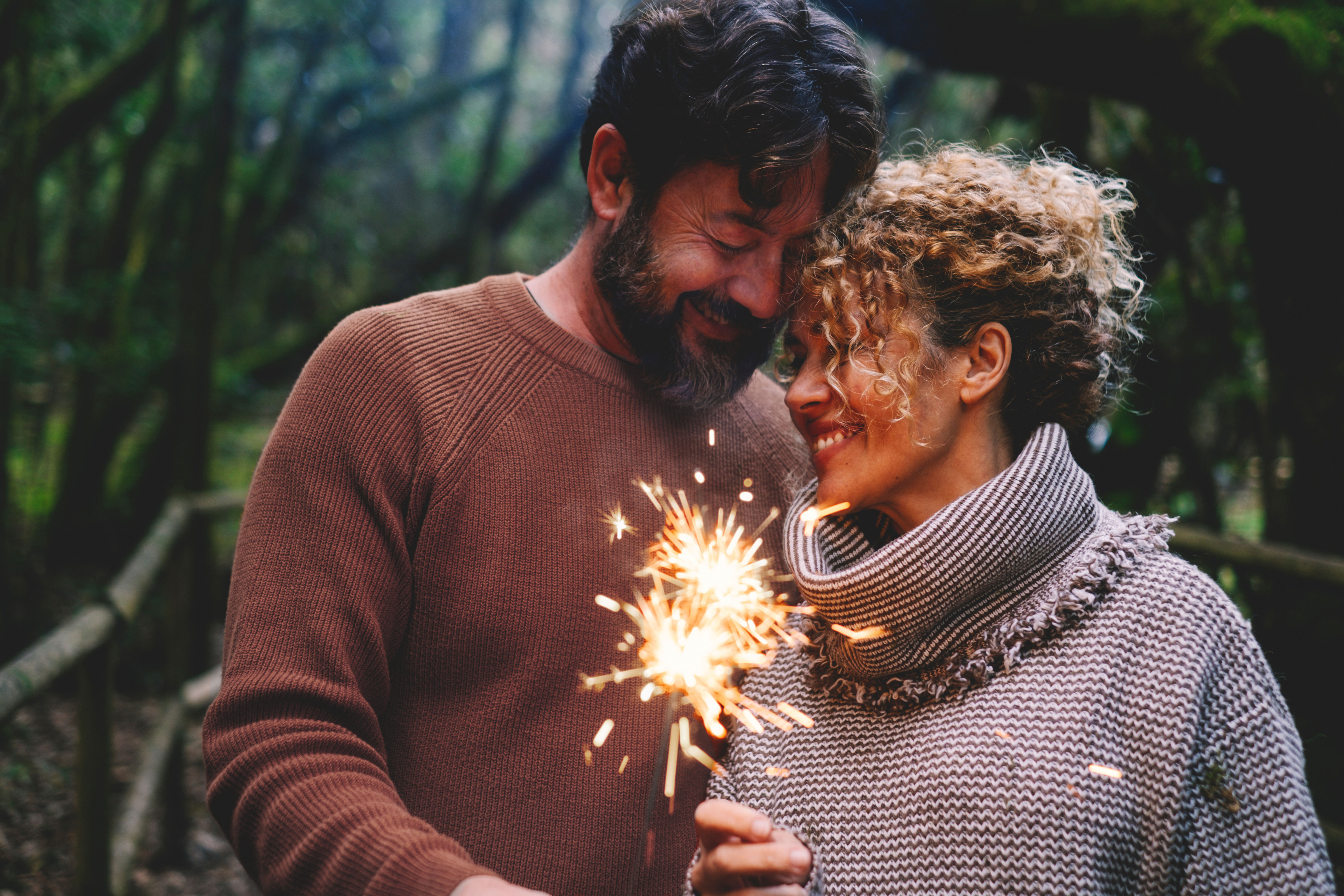 man and woman couple holding sparklers during new years
