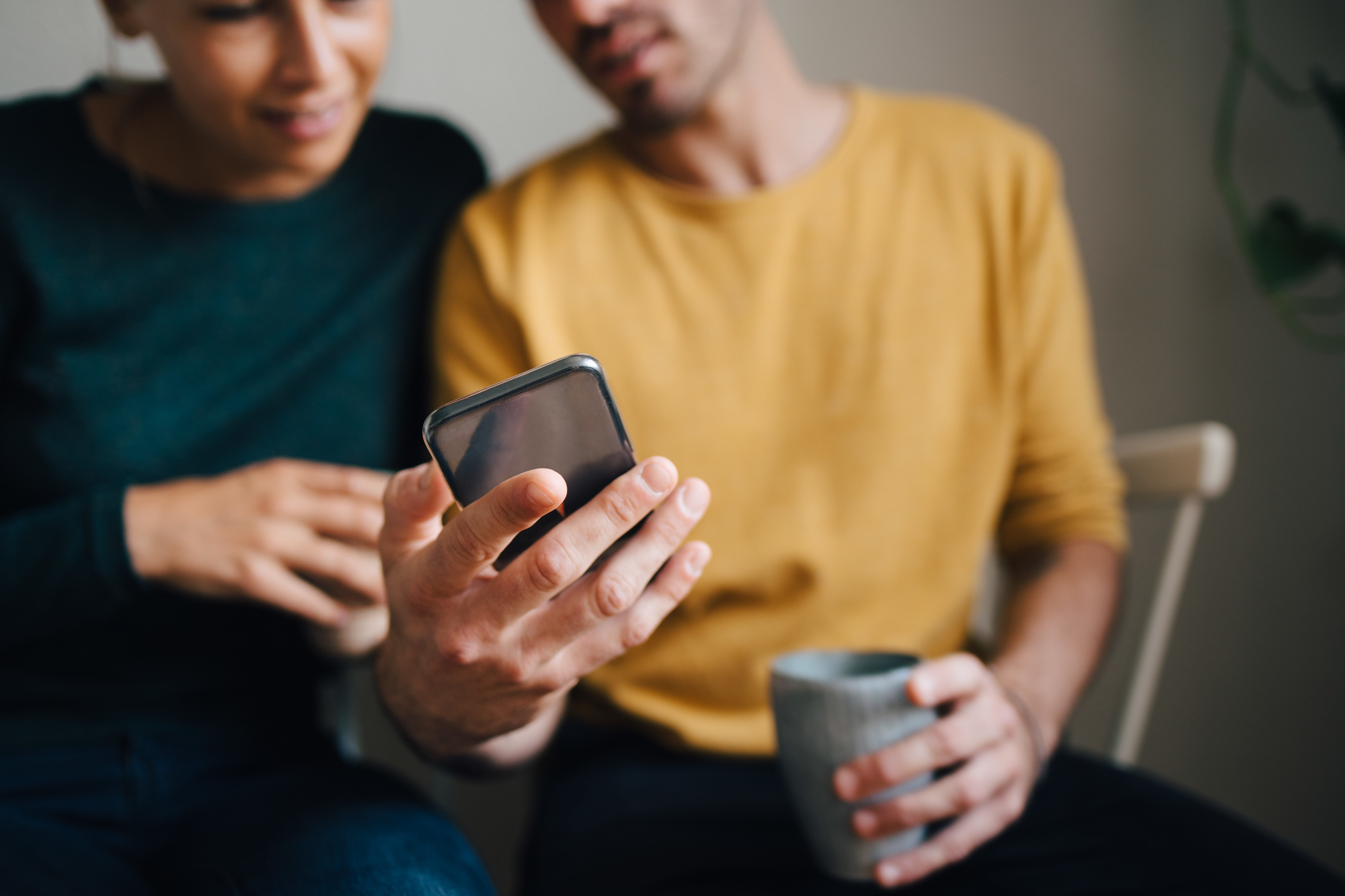 man and woman looking at phone
